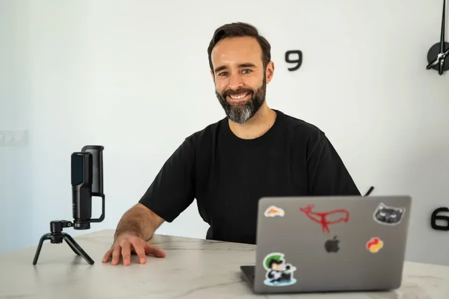 Alfonso Moure sonriendo en su escritorio, listo para conversar