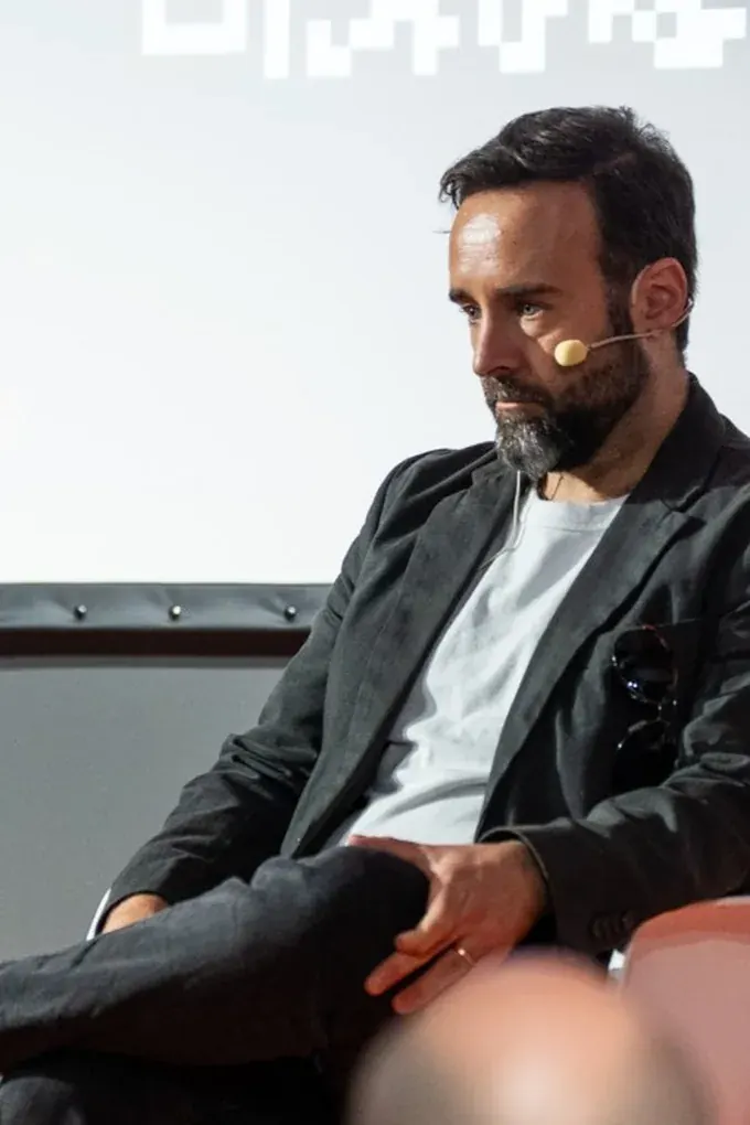 Alfonso Moure en un panel con micrófono de diadema